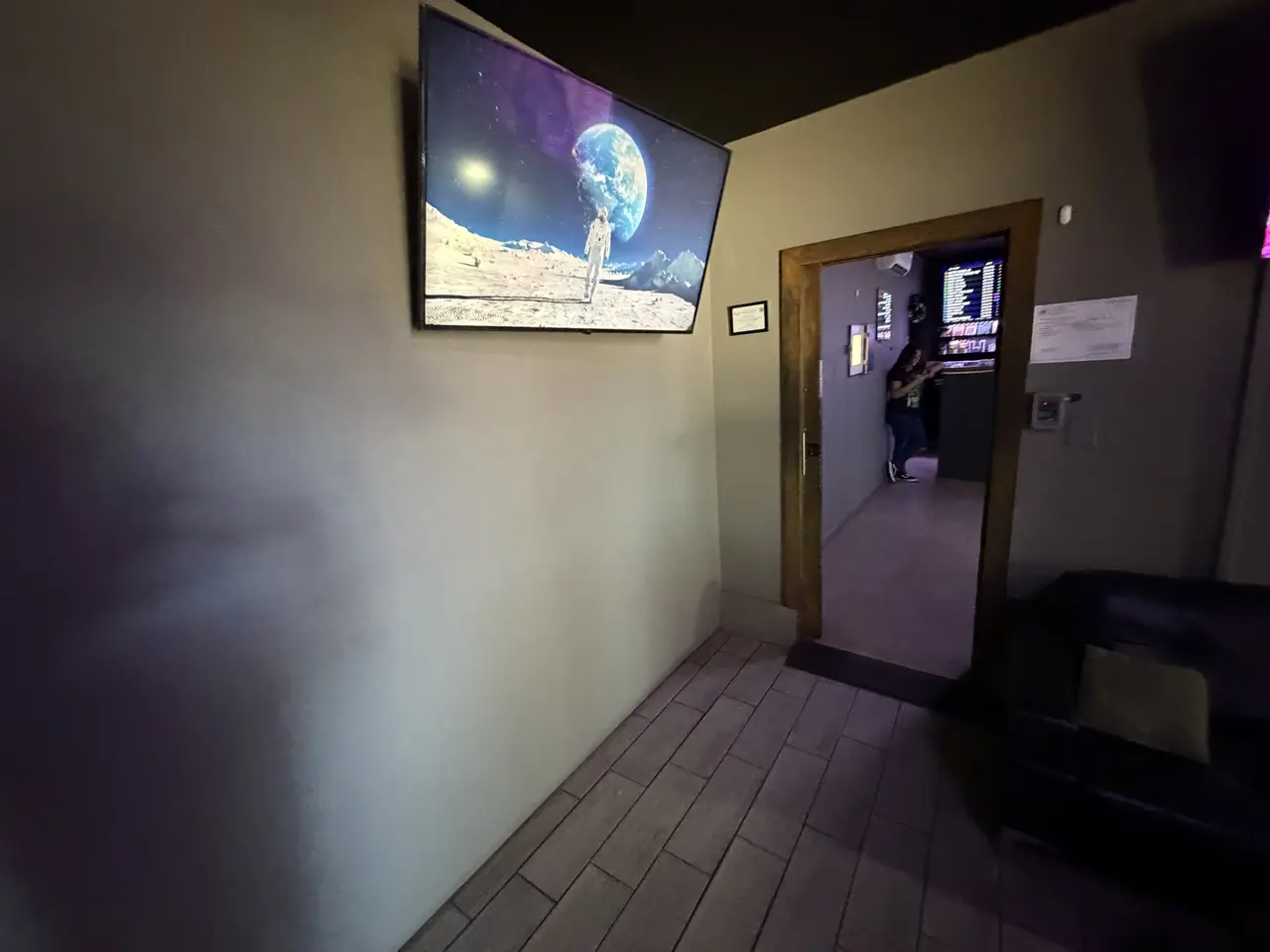 The door from the waiting room into the shop, with the menu screens visible through it